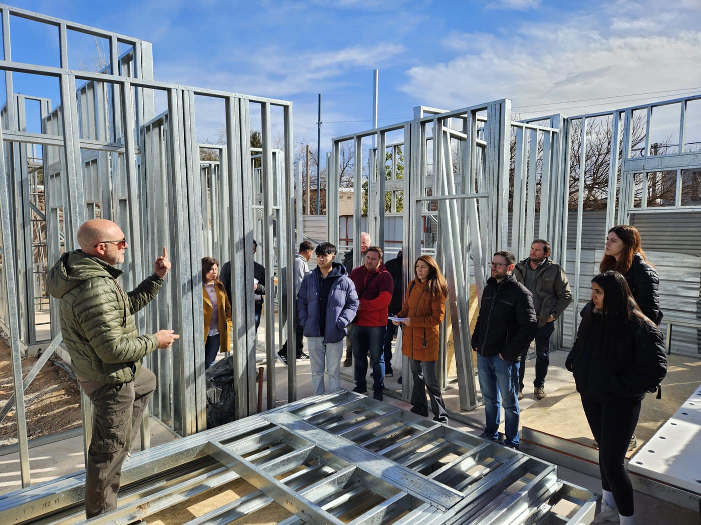 Profesional de Steel Framing explicando el sistema constructivo a un grupo en obra